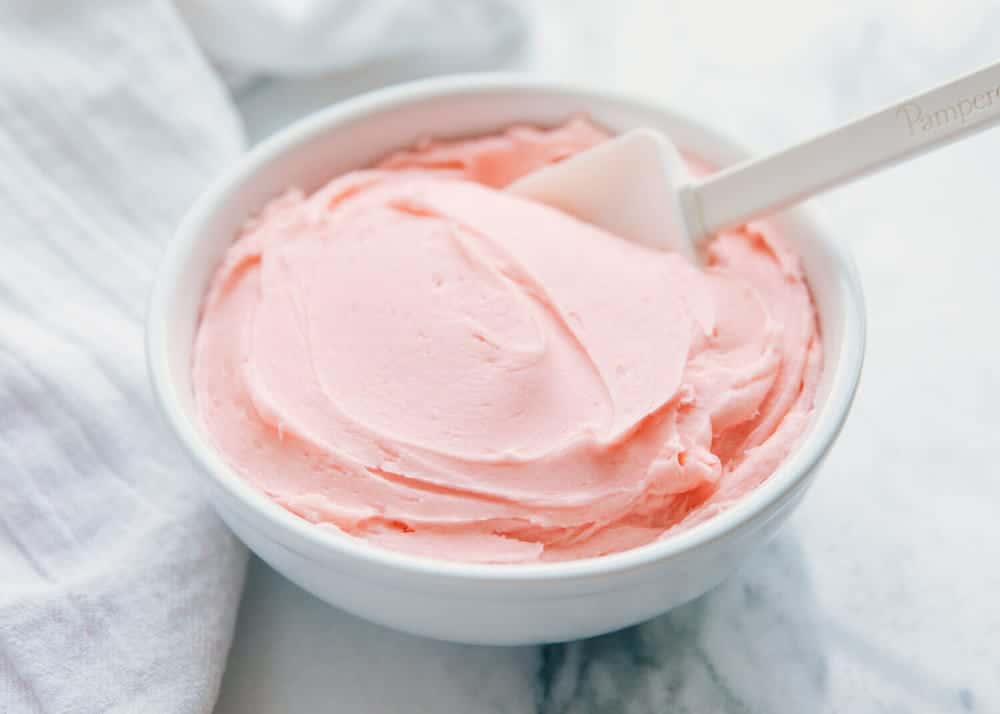 Bowl of pink buttercream frosting.