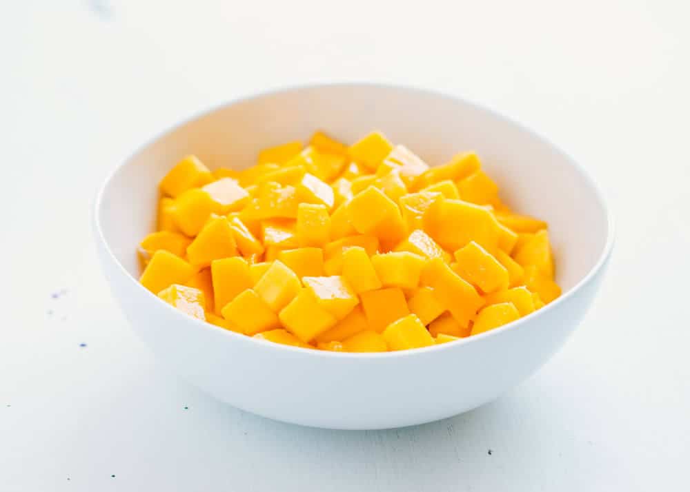 Diced mango in a white bowl.