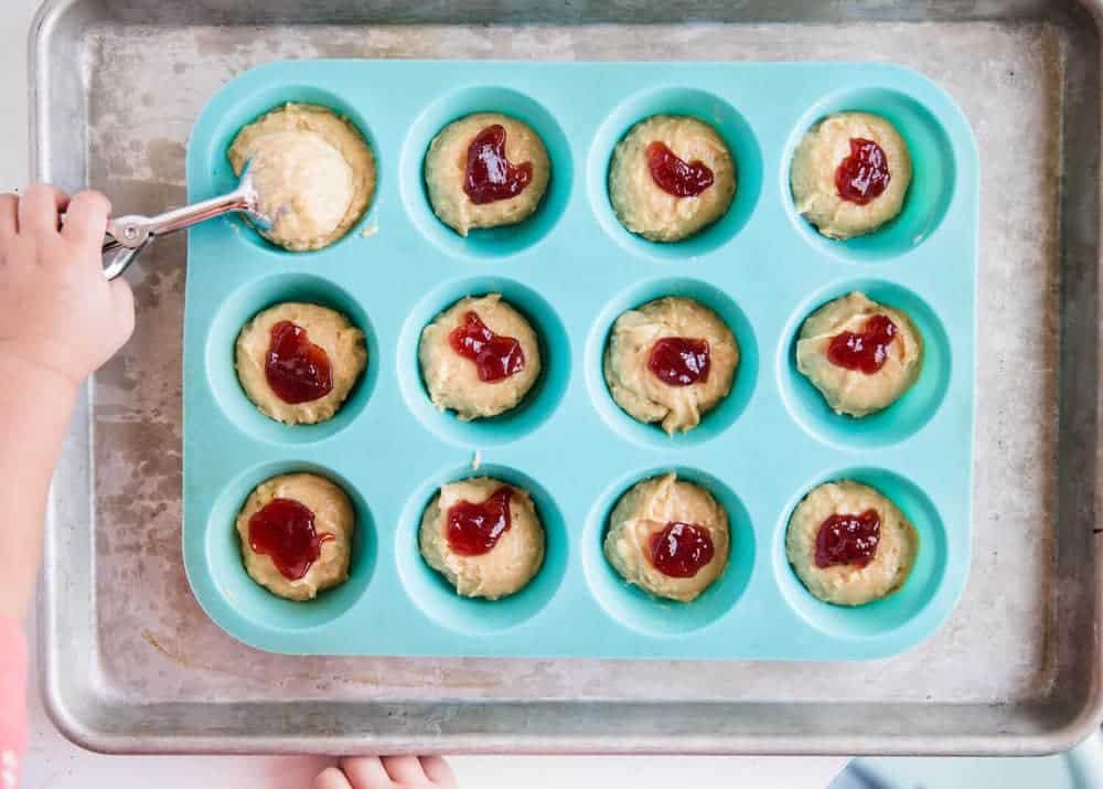 Scooping muffin batter into silicone pan.