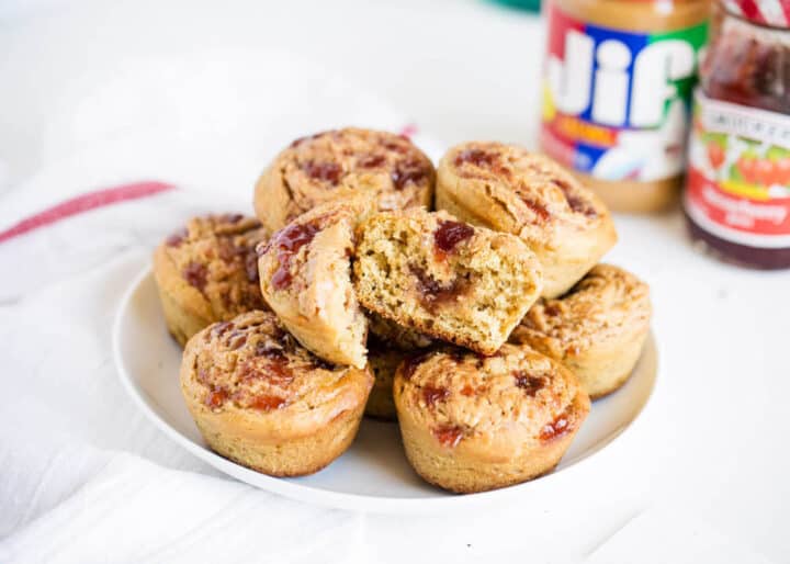 peanut butter and jelly muffins stacked on a white plate 