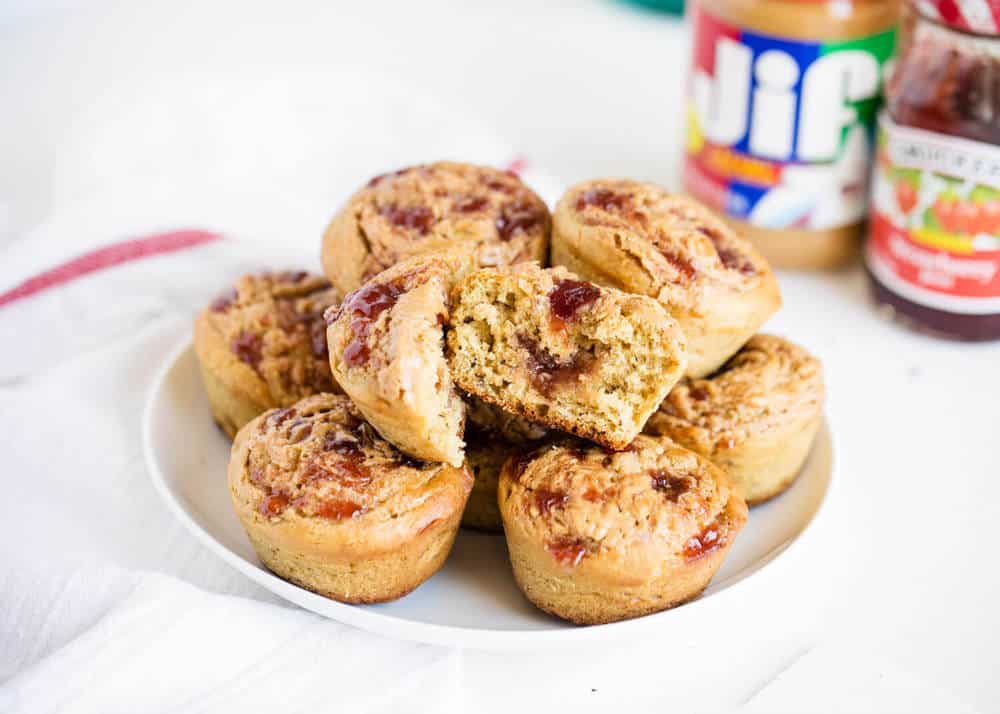 Peanut butter and jelly muffins stacked on a white plate.