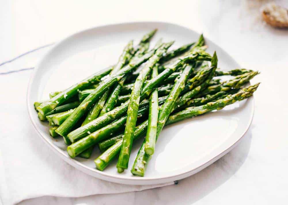 Roasted asparagus on a white plate.