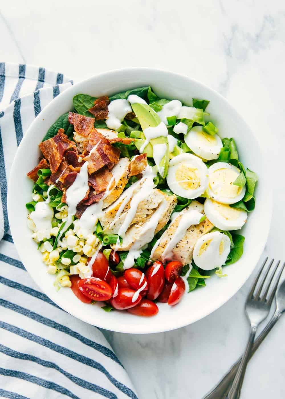 Cobb salad with ranch drizzled on top .