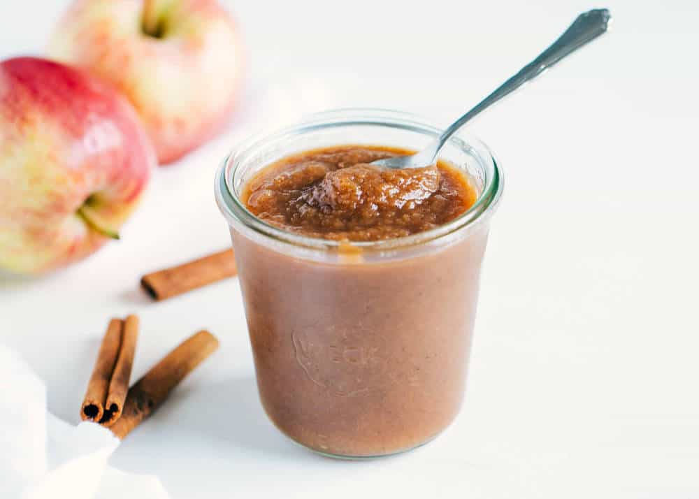 Apple butter in glass jar with spoon.