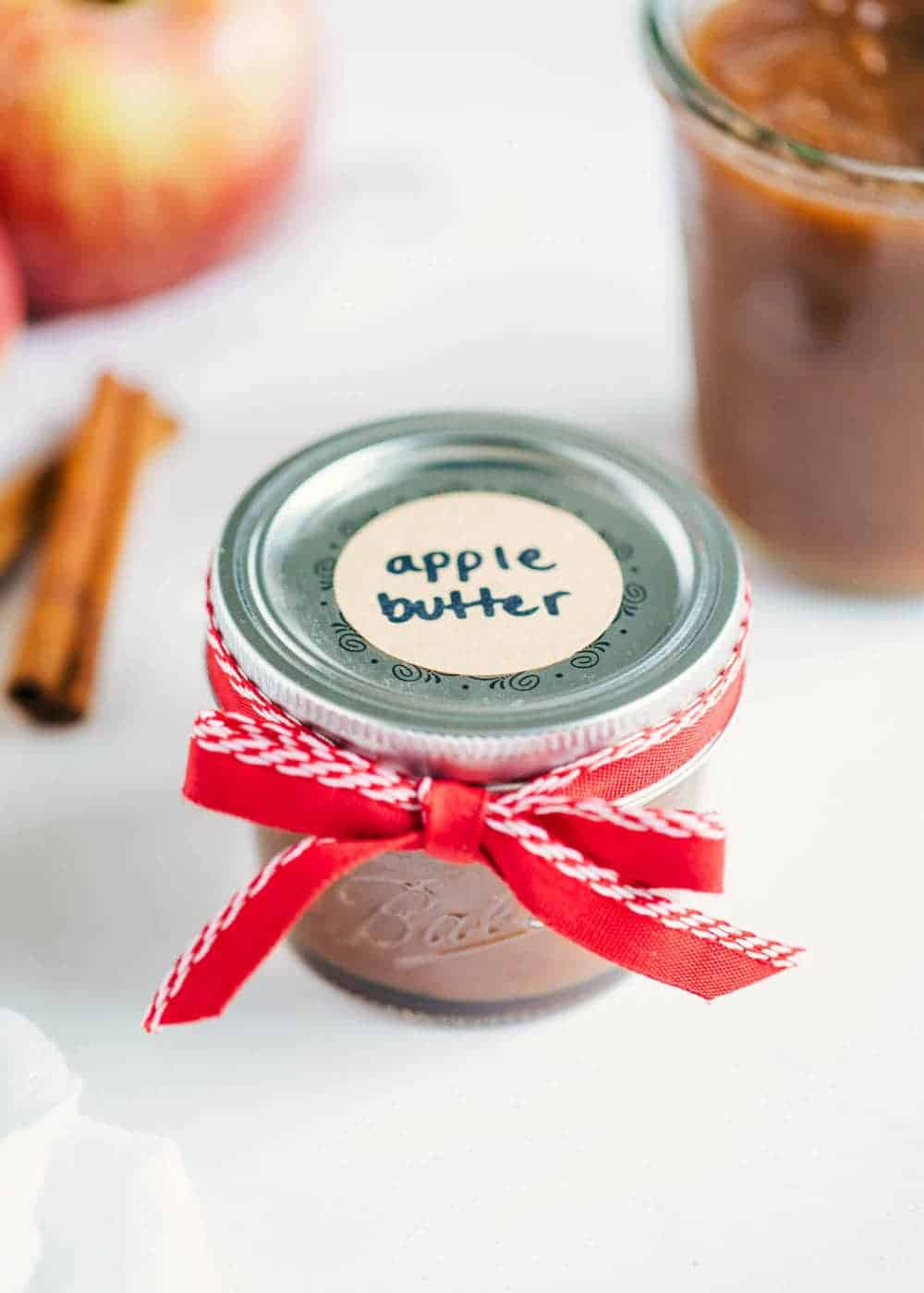 Apple butter in small jar with label and ribbon.