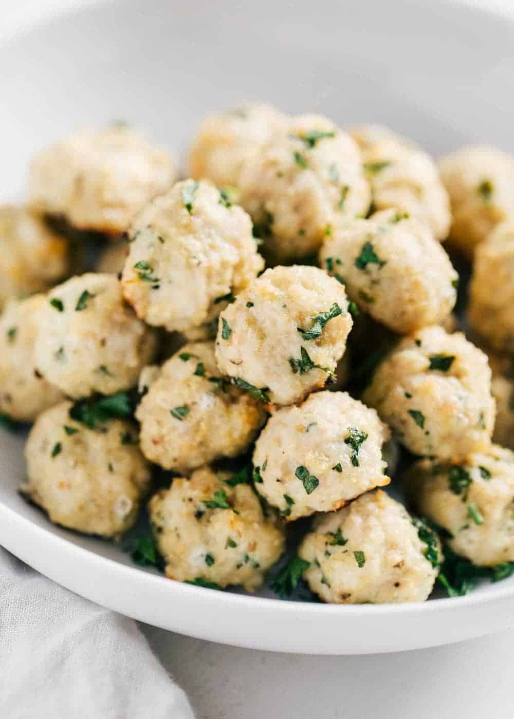 Stack of healthy turkey meatballs in a white bowl.