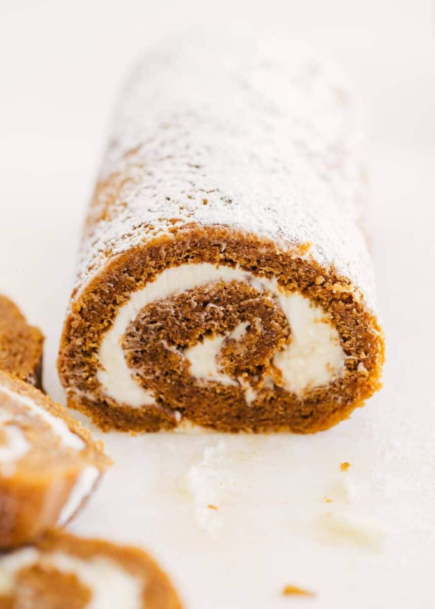 Delicious layers of fluffy pumpkin cake and sweet cream cheese filling swirled together to make the ultimate treat! This easy pumpkin roll is perfect to serve during the fall season. pumpkin roll dusted with powdered sugar