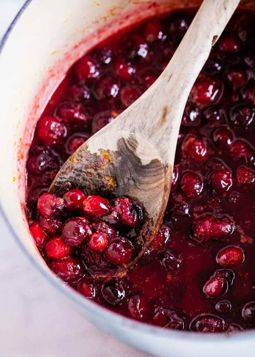 cranberry sauce in pot with wooden spoon 