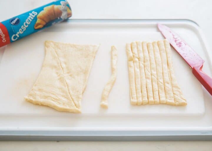 cutting crescent dough into strips 