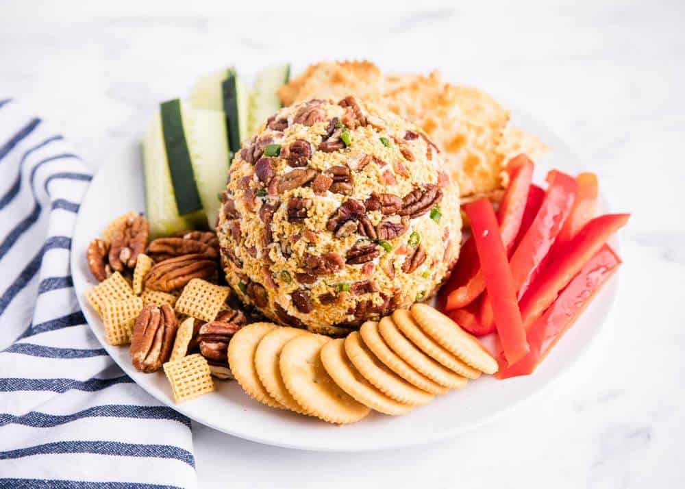 bacon ranch cheese ball on a plate with crackers and veggies 