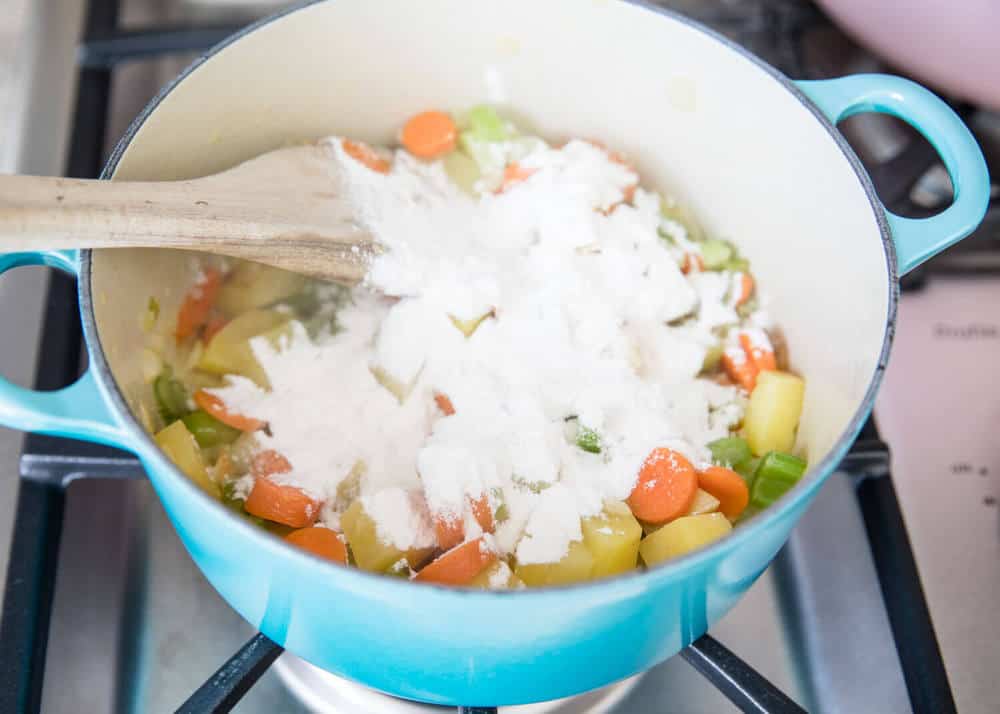 Cooking veggies and flour in large pot .