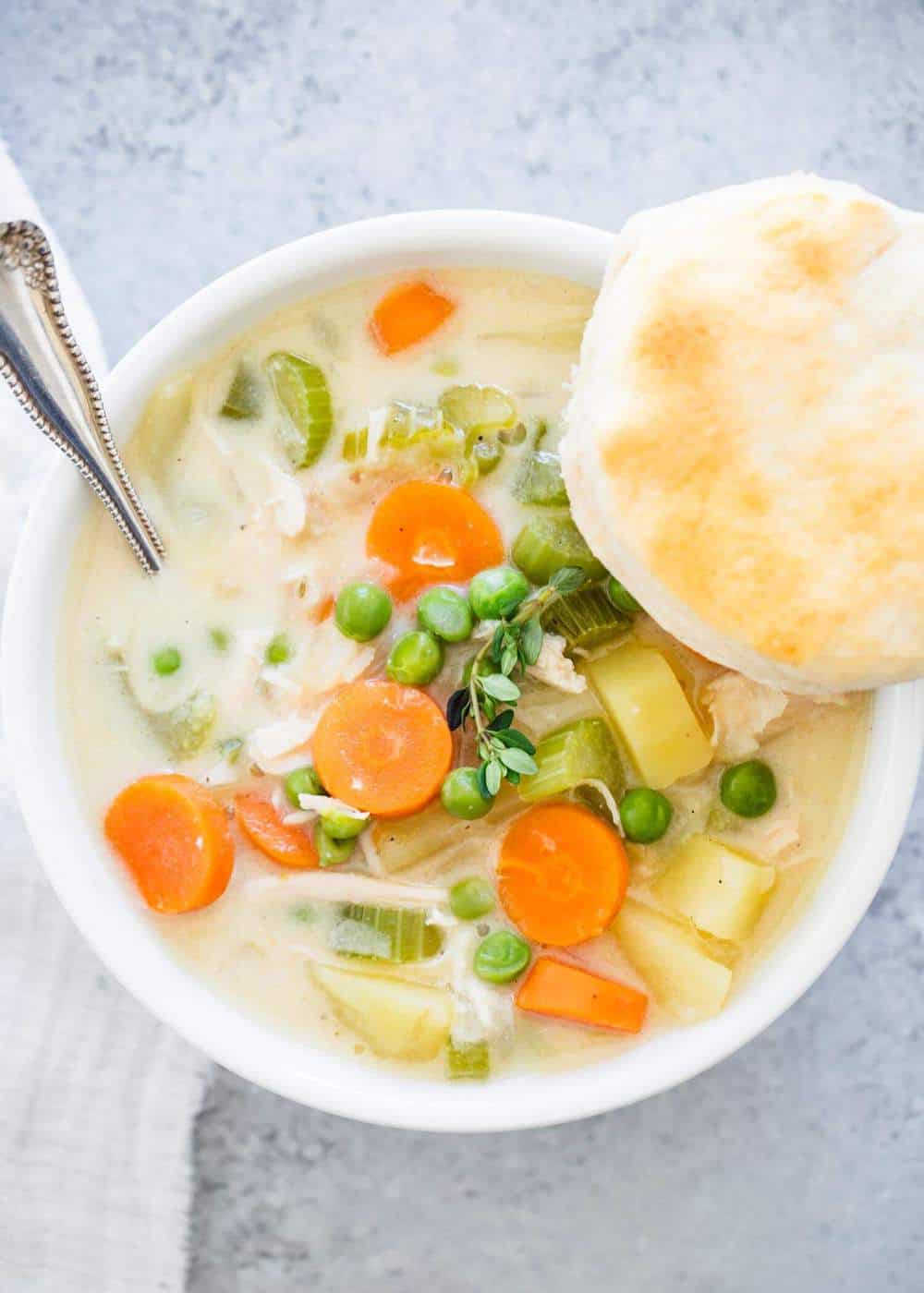 Bowl of chicken pot pie soup with biscuit.