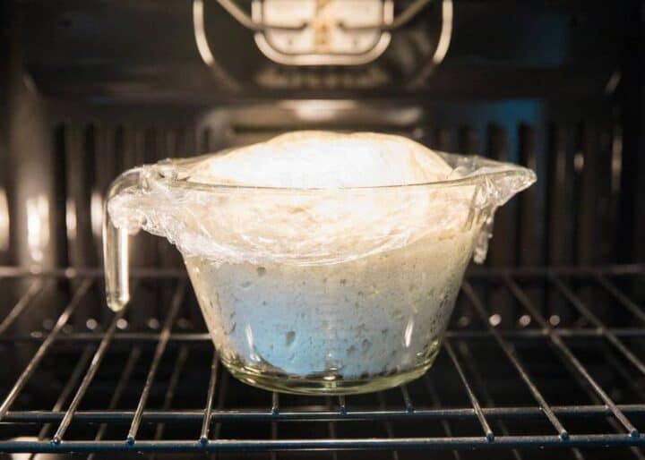 letting dough rise in a glass measuring cup in the oven