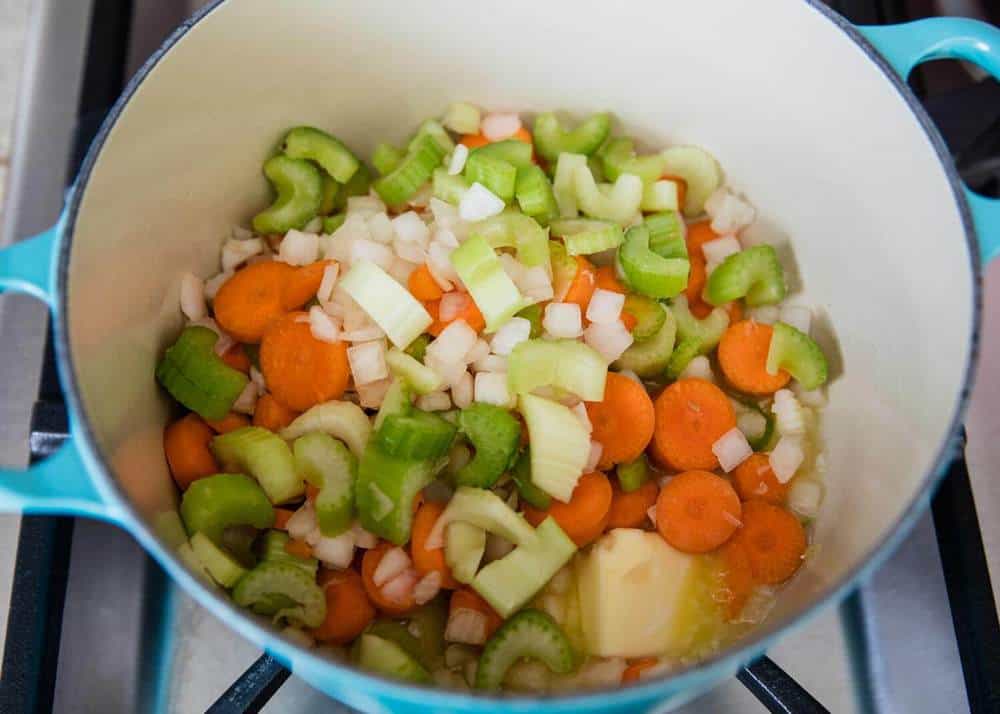 chopped onion, celery and carrots in a dutch oven pan with butter 