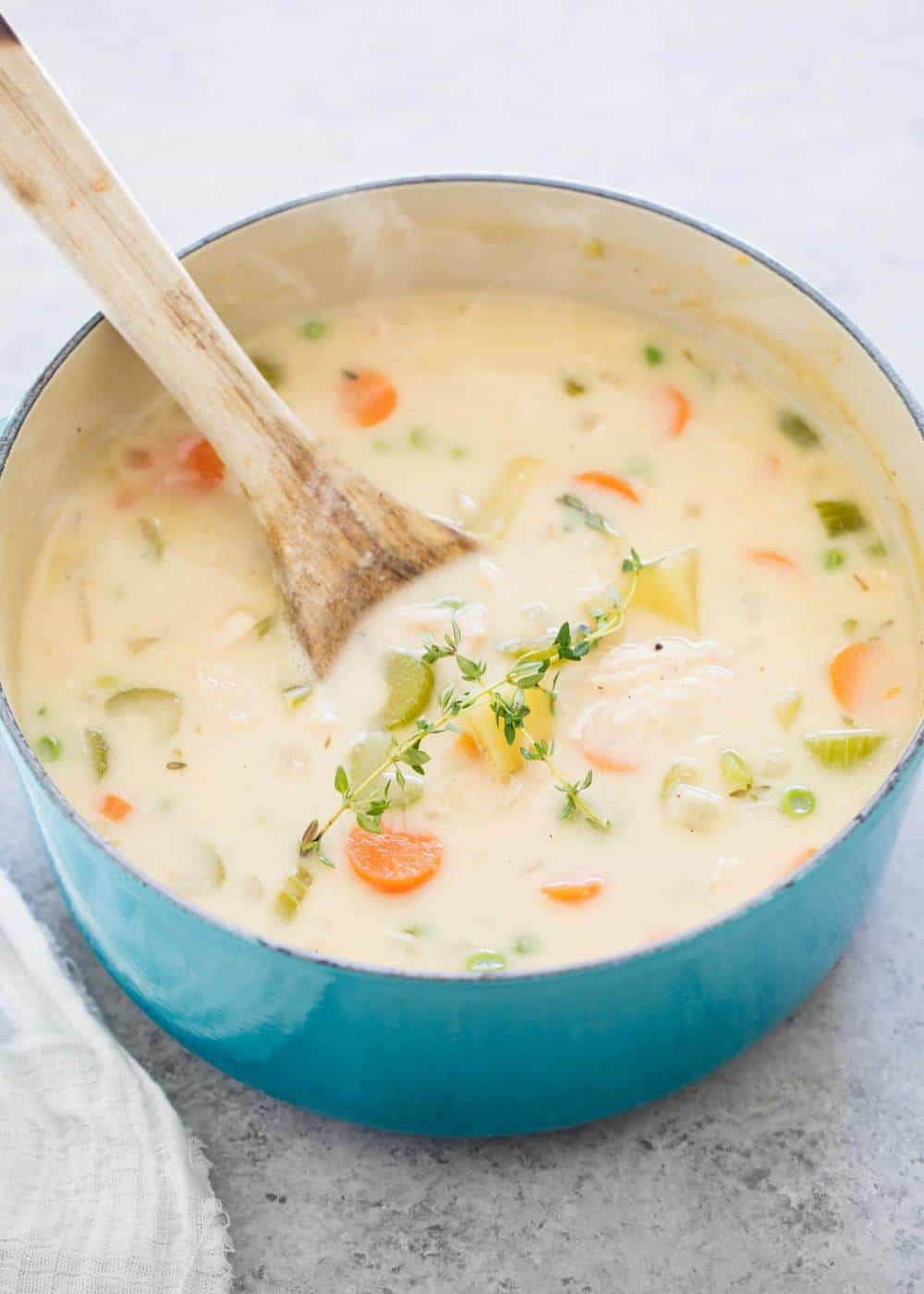 Pot pie soup in large pot with wooden spoon.
