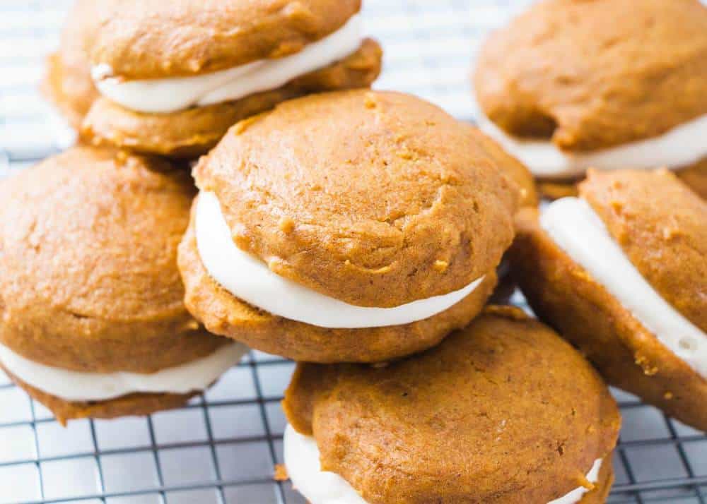 Pumpkin whoopie pies on cooling rack.