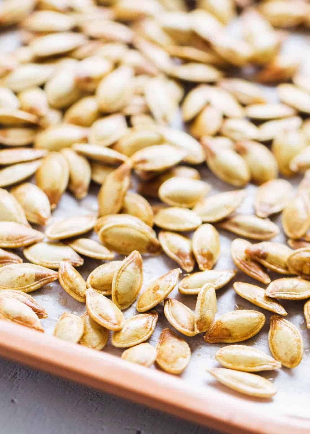 Roasted pumpkin seeds on baking sheet.