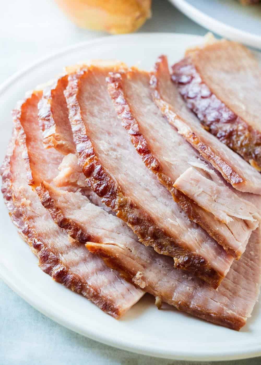 Slices of spiral ham on a white plate.