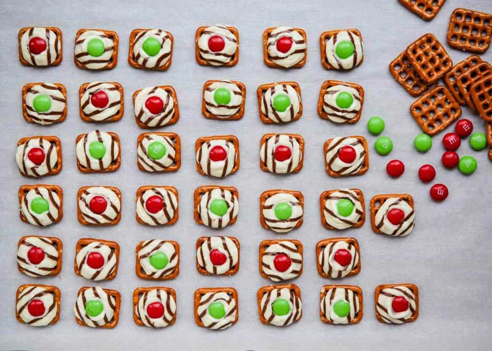 Pretzel kisses lined up on parchment paper.