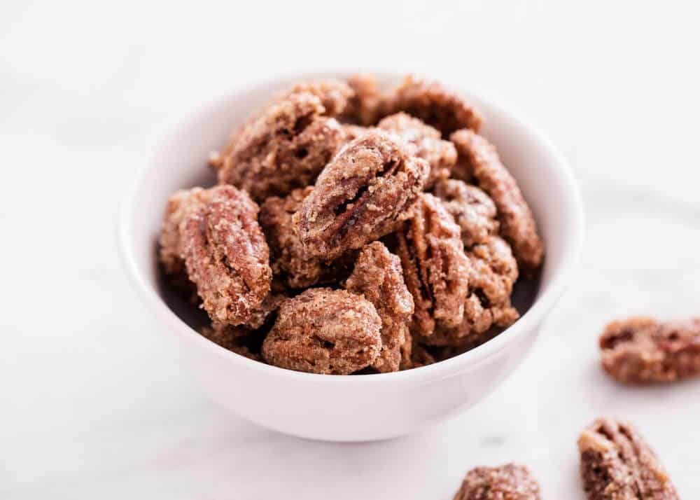 Candied pecans in white bowl.