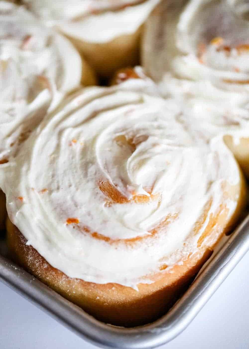 Close up of a frosted orange roll.