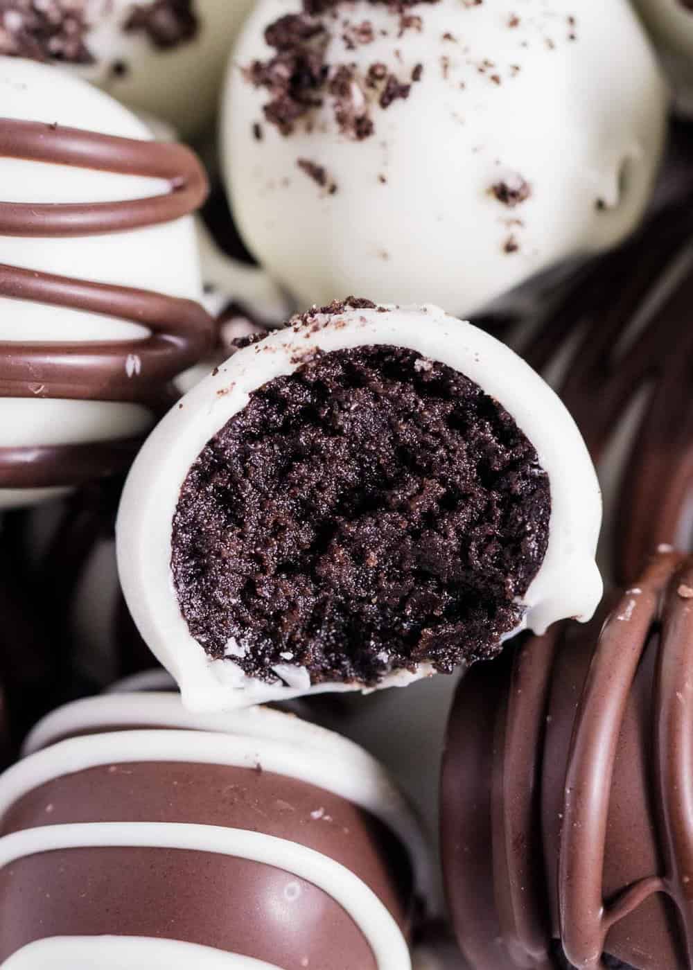 Oreo balls dipped in chocolate with a bite taken.