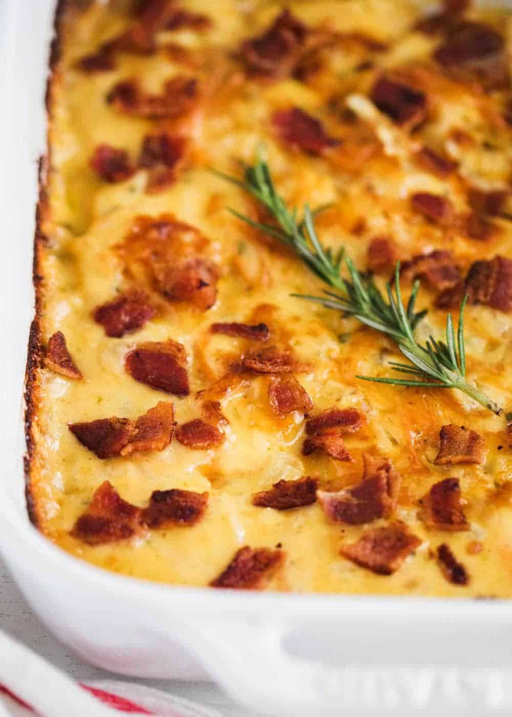 Scalloped sweet potatoes with bacon in pan.