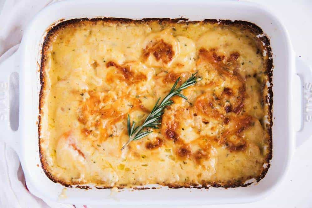 Scalloped sweet potatoes in baking dish.