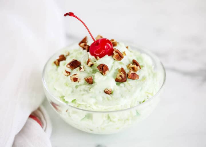watergate salad in a glass bowl with a cherry on top 