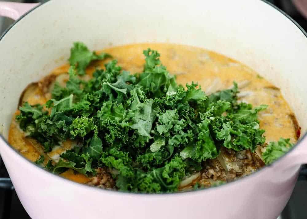 Adding fresh kale in zuppa toscana soup.