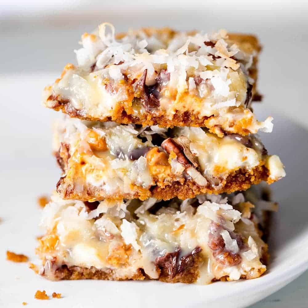 Stack of 7 layer bars on a white plate.