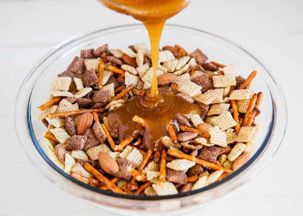 Caramel chex mix in a glass bowl. 