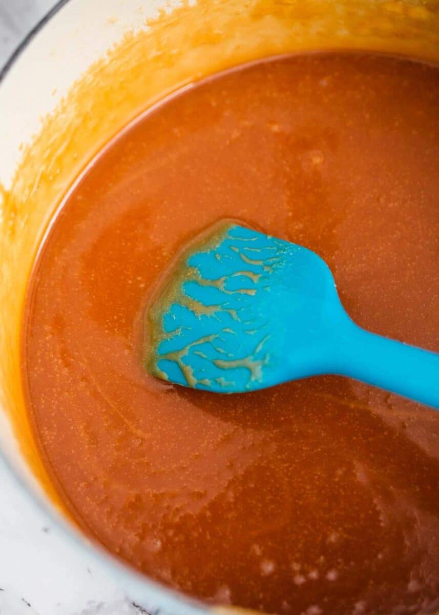 stirring caramel sauce in pan with spatula 