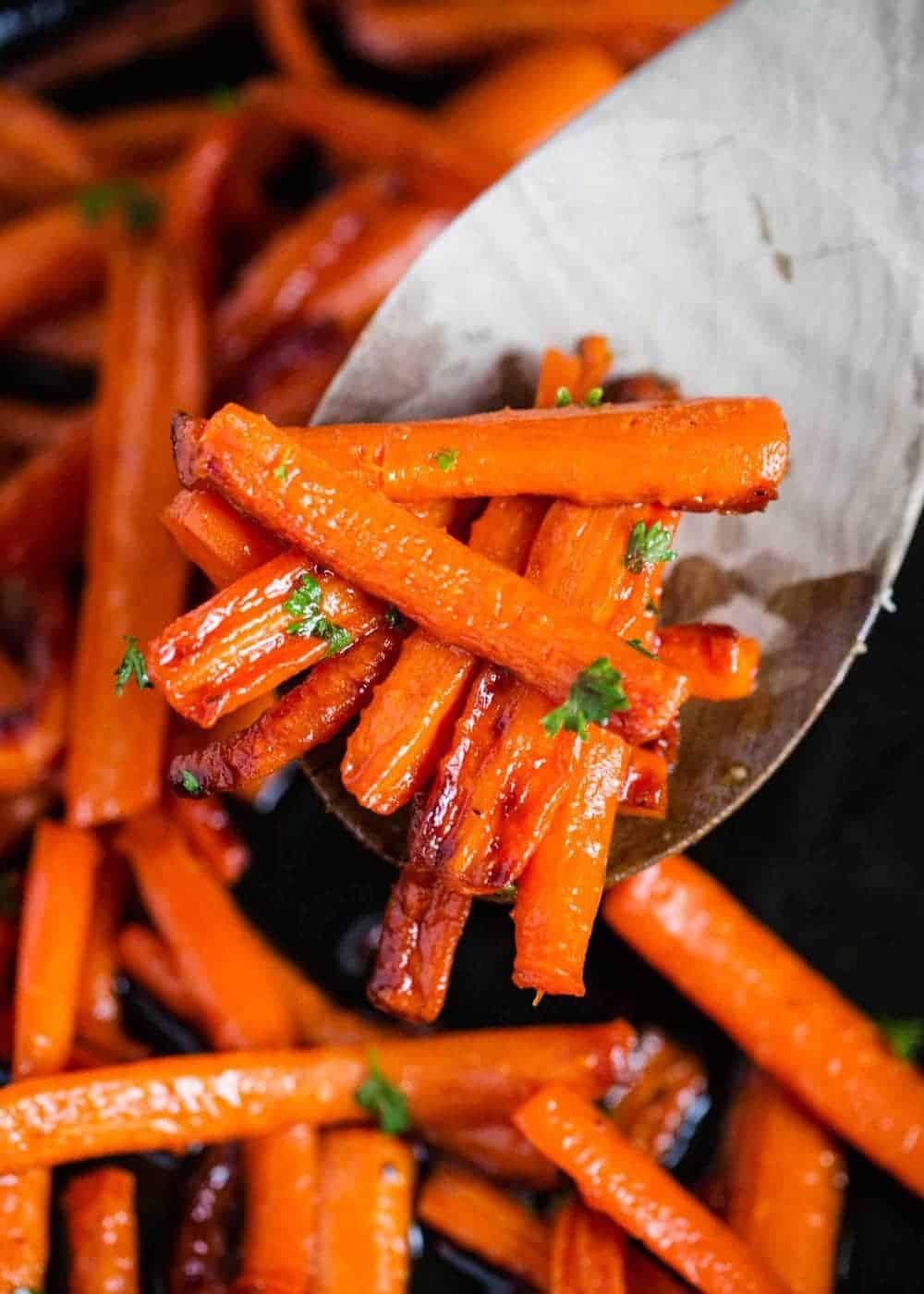 Perfectly caramelized glazed carrots that are crispy and have a hint of sweetness. Require only 3 simple ingredients and can be made on the stove, oven or crockpot! Spoonful of glazed carrots.