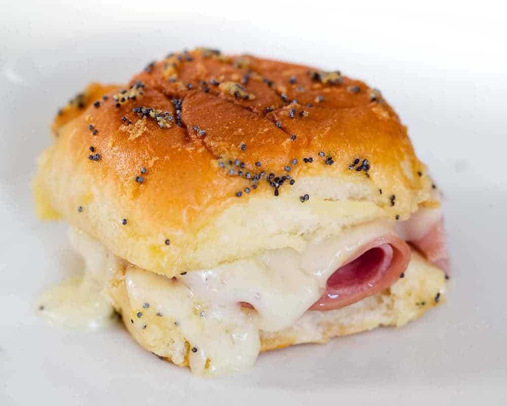 Ham and cheese slider with melted cheese oozing out.