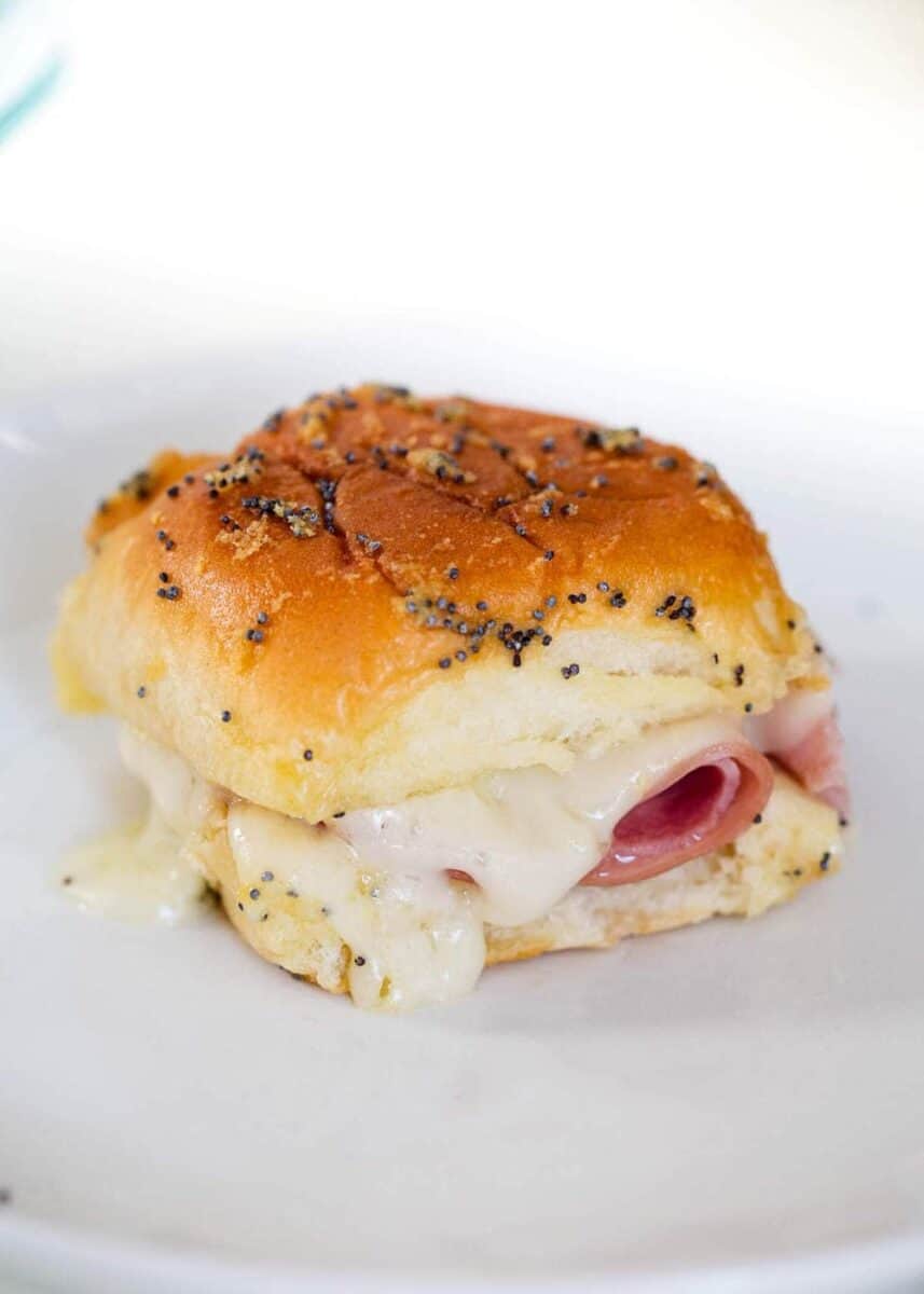 ham and cheese slider with poppy seed sauce on top 