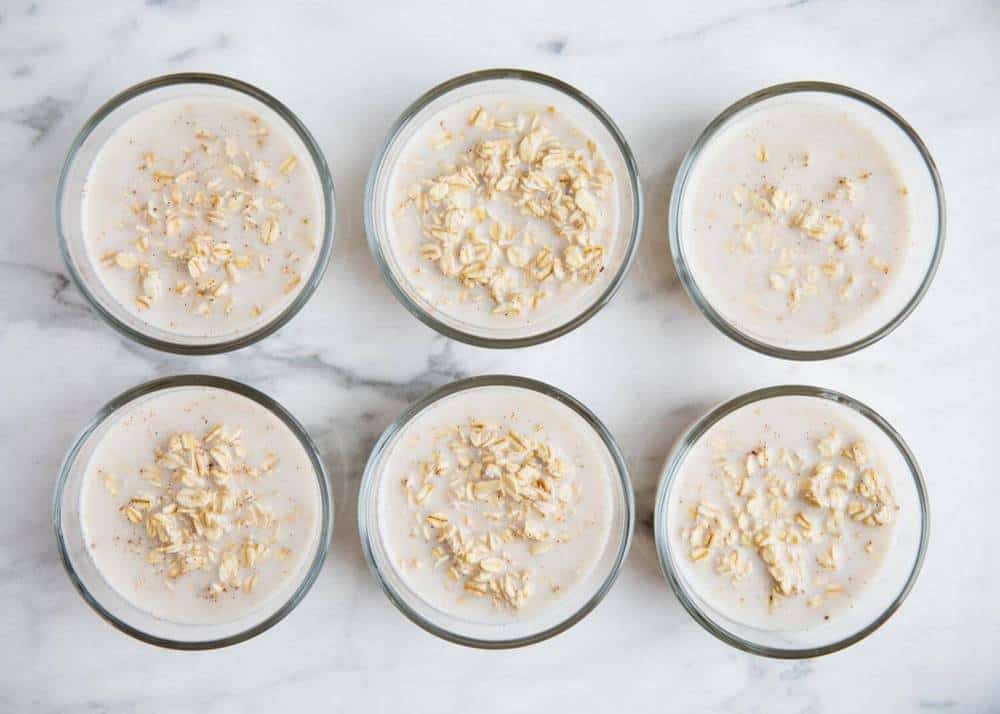 Dividing overnight oats base mixture into bowls.