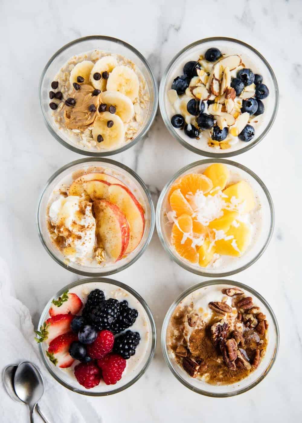 6 different combinations of overnight oats on counter.