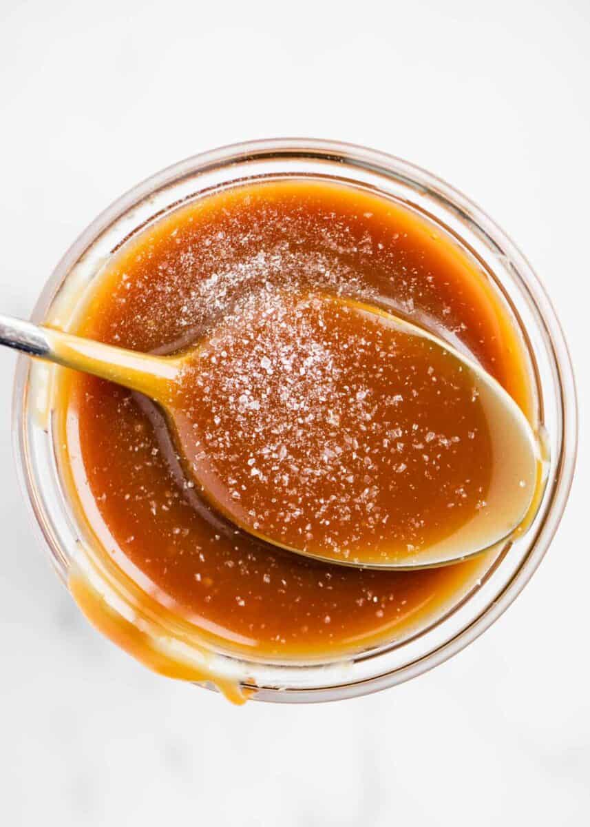 salted caramel sauce in jar with spoon 