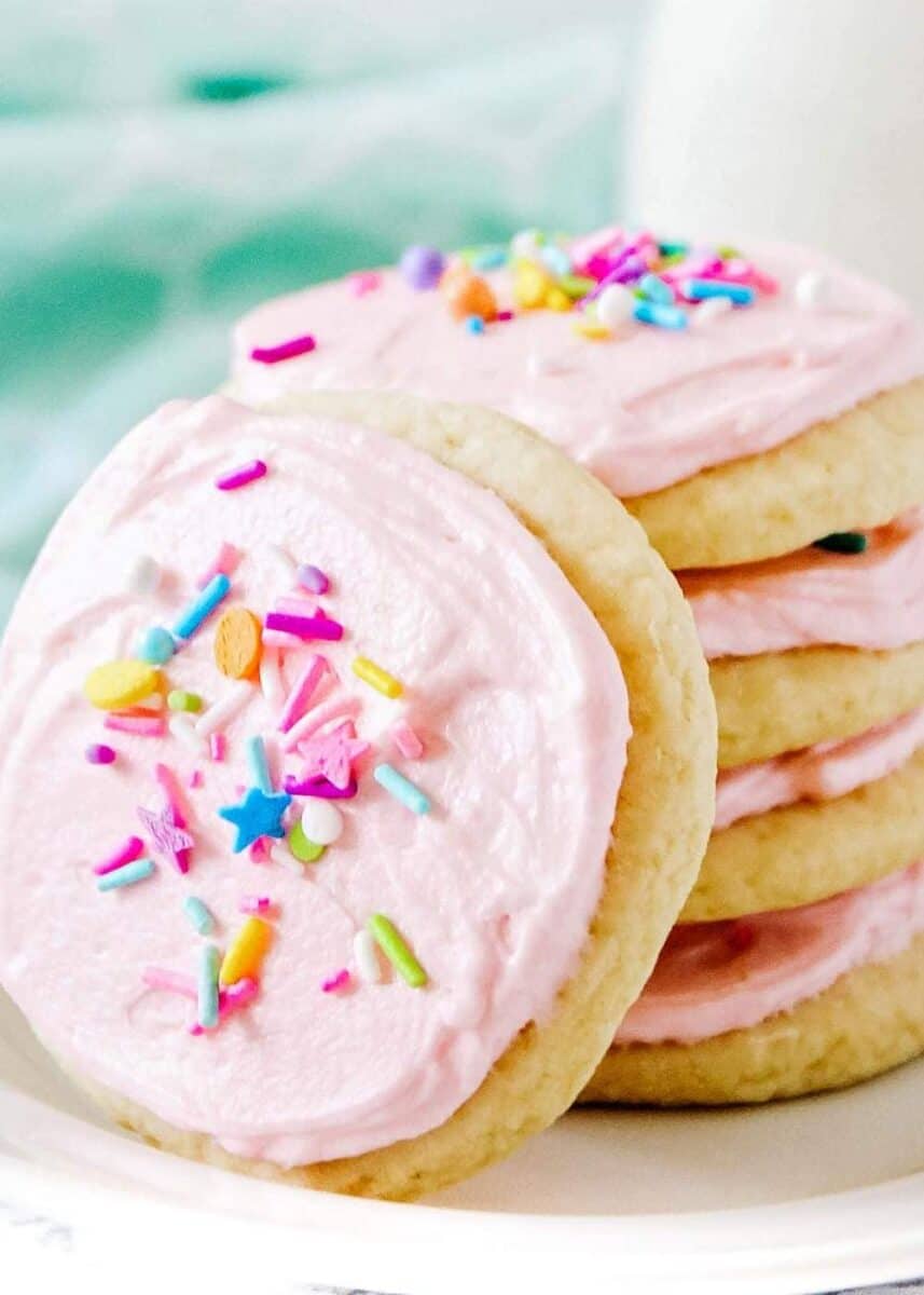 close up of sugar cookies with pink frosting and sprinkles 