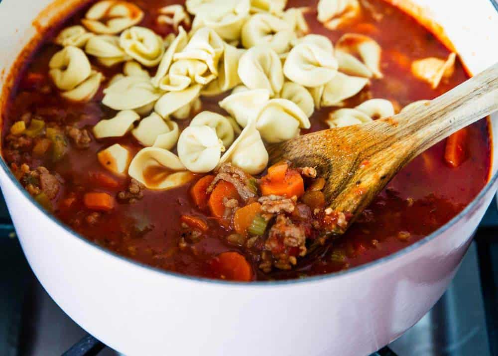 Cooking sausage tortellini soup in pot.