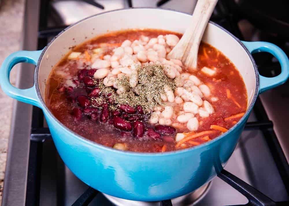 Making pasta e fagioli in blue pot on stove.