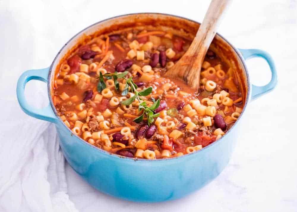 Pasta fagioli in pot with wooden spoon.