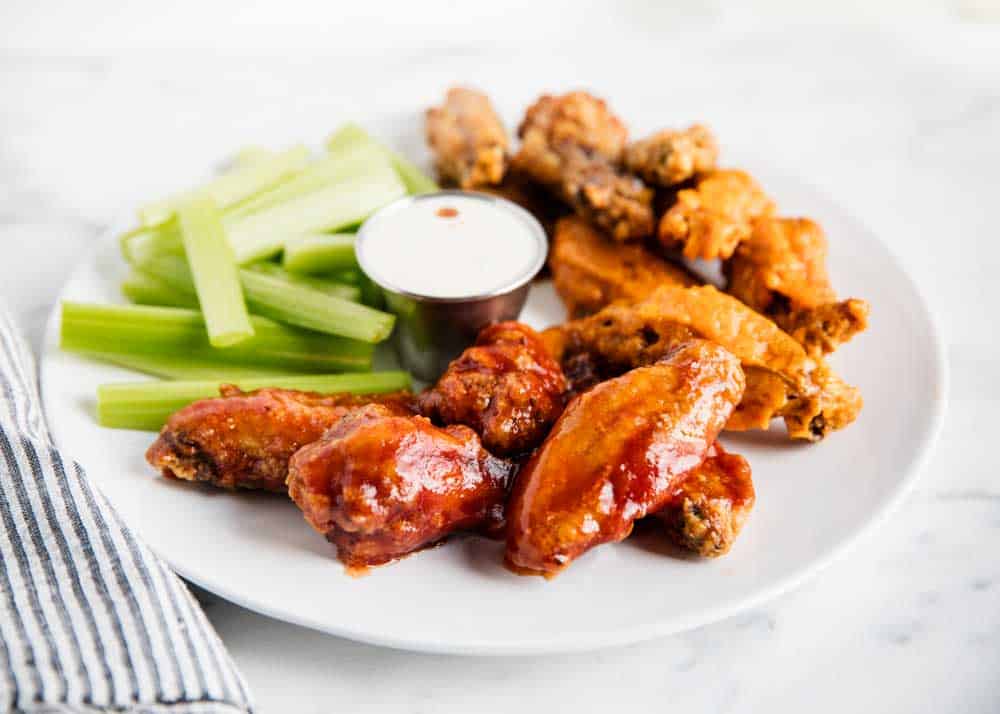 Chicken wings with celery and ranch on a plate.