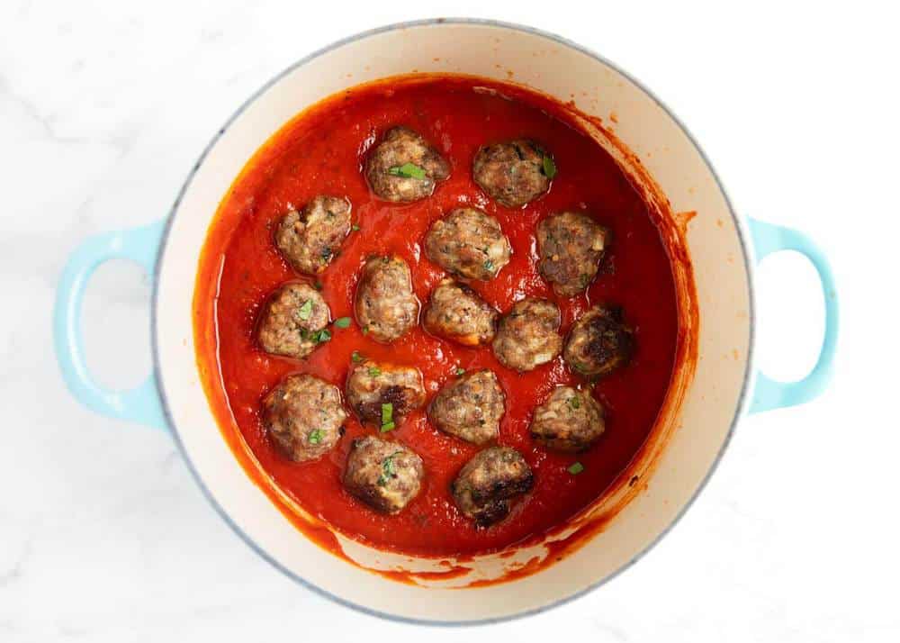 This easy meatball recipe is so easy to make and come out juicy and flavorful every time. They're perfect for appetizers, subs or on top of spaghetti! Meatballs in a pot with marinara sauce