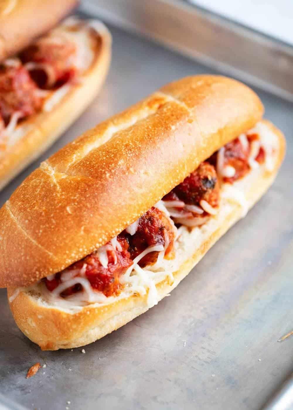 Homemade meatball subs on baking sheet.