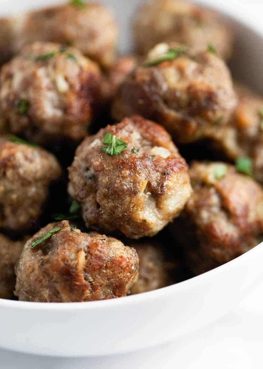 Stacked meatballs in a white bowl