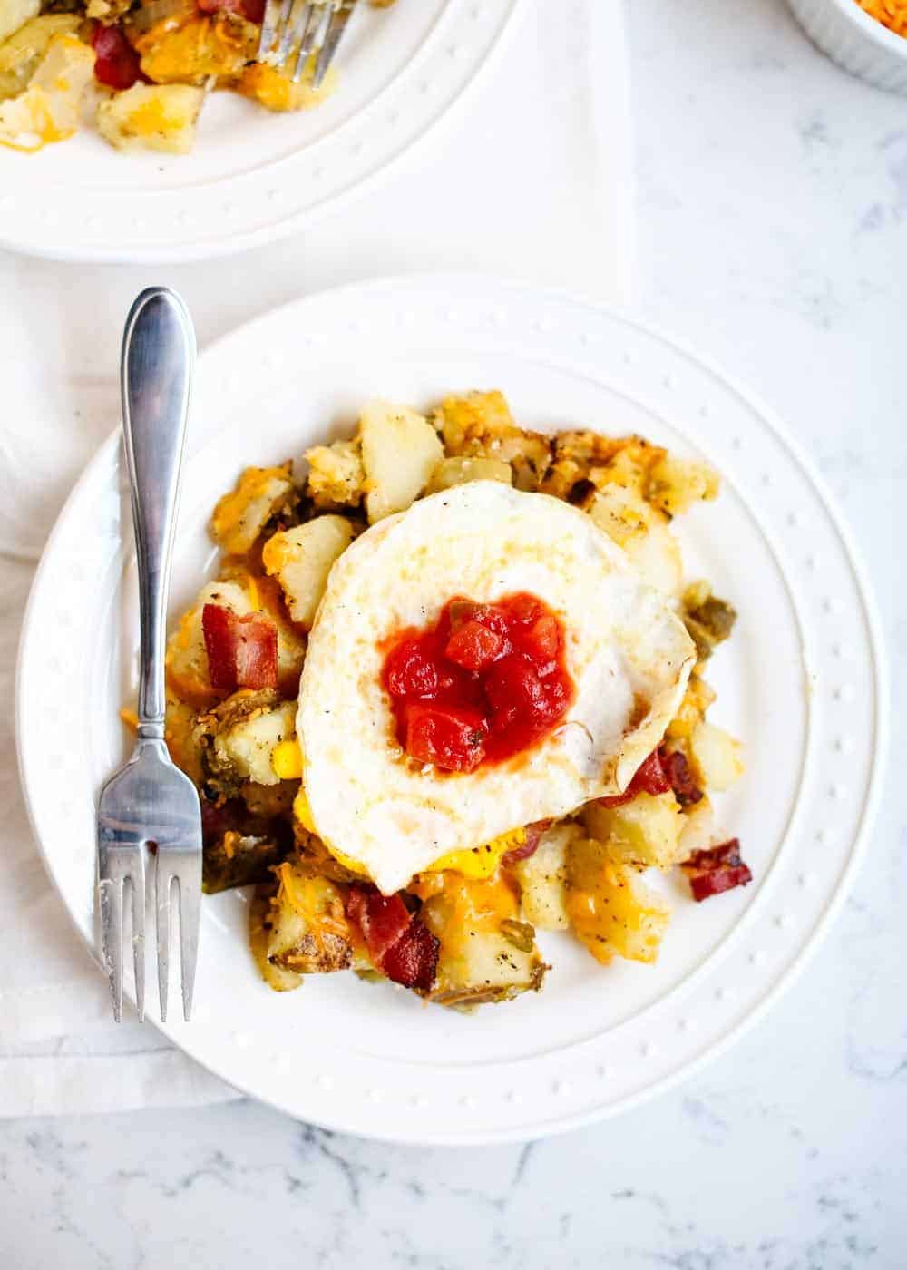 Breakfast potatoes and egg on plate.