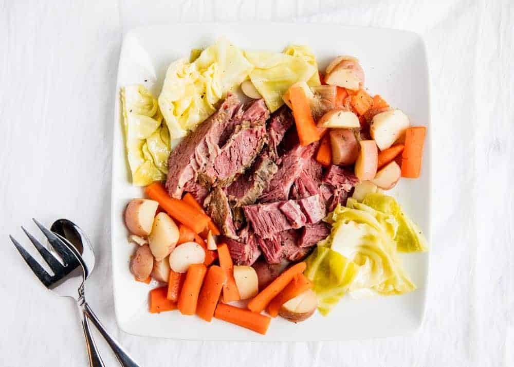 Corned beef and cabbage on white plate.