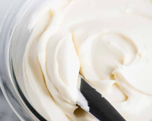 spreading cream cheese frosting with knife